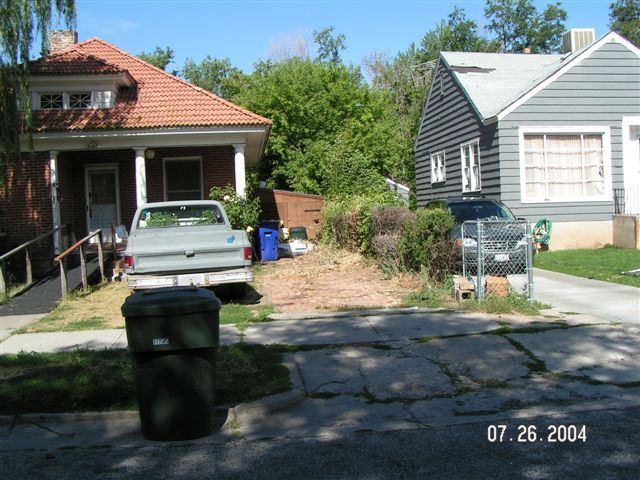 A red brick house with an empty driveway and snow on the ground.